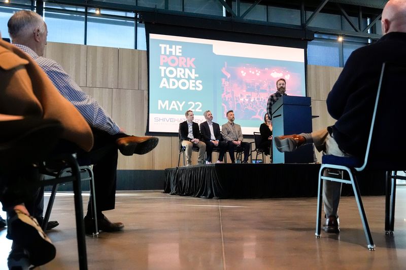 Pork Tornados drummer Mike Schulte speaks to the assembled crowd Feb. 11, 2026 about the band’s upcoming performance at the Hy-Vee Center at Centennial Park in North Liberty, Iowa.