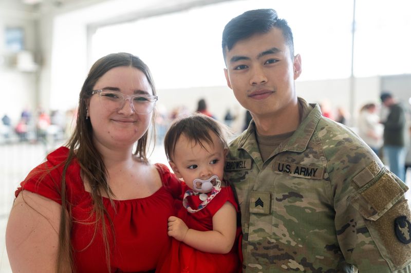 From left: Camry, Juniper and Isaiah Birdwell stand for a portrait as Isaiah returns from deployment on Feb. 11, 2026, at the 132d Air Wing at the Des Moines International Airport.