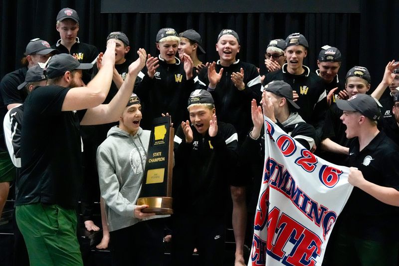 The Iowa City West Trojan swimming team celebrates with their team championship trophy Feb. 14, 2026 during the Iowa High School Boys State Swim Meet Finals at the University of Iowa Aquatic Center in Iowa City, Iowa.