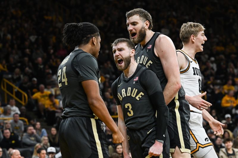 Feb 14, 2026; Iowa City, Iowa, USA; Purdue Boilermakers guard Gicarri Harris (24) and guard Braden Smith (3) and center Oscar Cluff (right center) react as Iowa Hawkeyes forward Cooper Koch (8) looks on during the first half at Carver-Hawkeye Arena. Mandatory Credit: Jeffrey Becker-Imagn Images