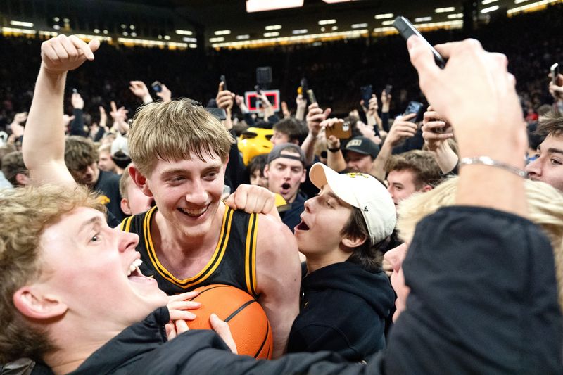 Iowa forward Cooper Koch (8) celebrates after Iowa fans stormed the court following the Hawkeyes win over the Nebraska Cornhuskers 57-52 Feb. 17, 2026 at Carver-Hawkeye Arena in Iowa City, Iowa.