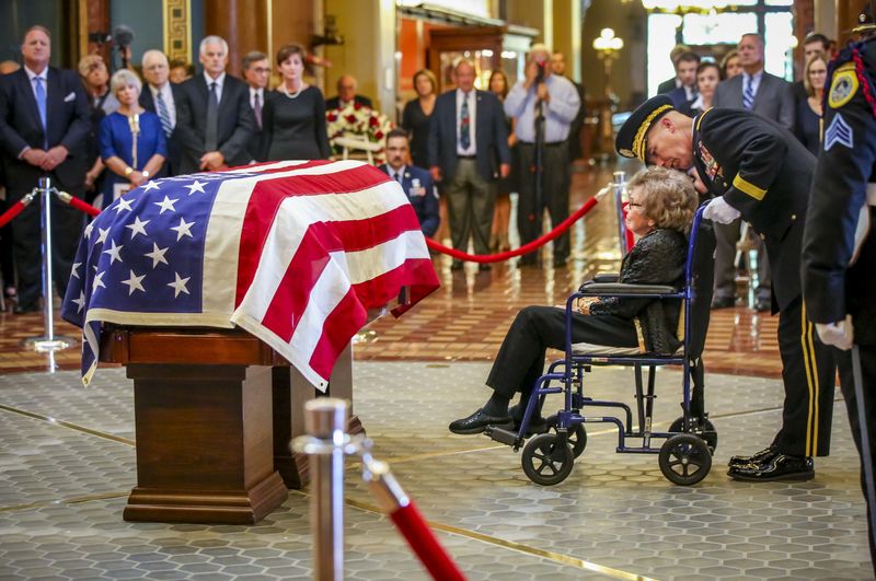 Former first lady Billie Ray pay her respects to her husband, former Iowa Gov. Robert Ray, in the rotunda Thursday, July 12, 2018, at the Iowa Statehouse with the assistance of National Guard. Major General Timothy E. Orr.