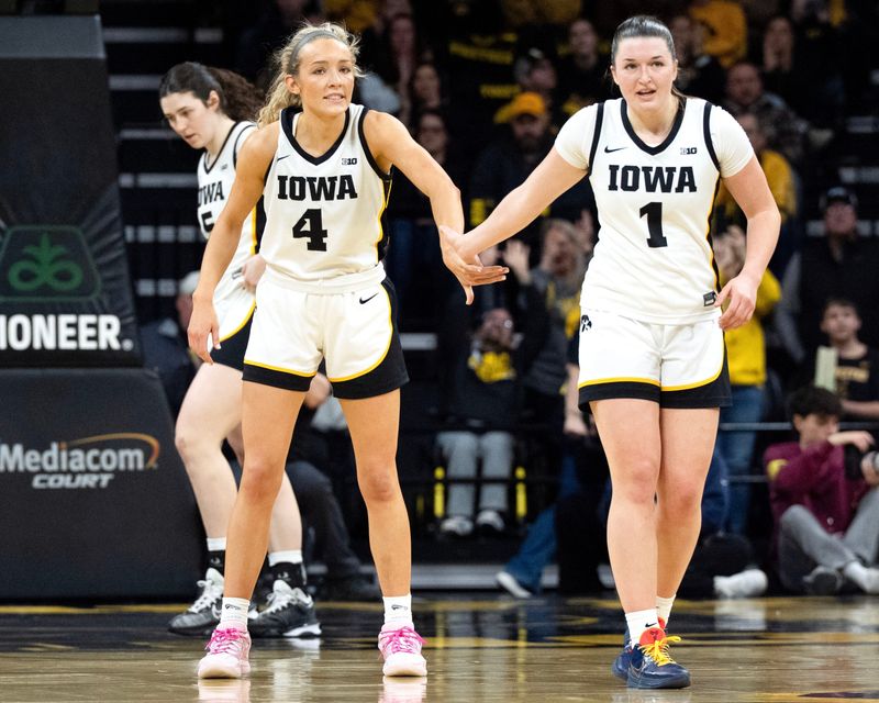 Iowa guard Kylie Feuerbach (4) high-fives Iowa guard Taylor Stremlow (1) during a basketball game against the Michigan Wolverines Feb. 22, 2026 at Carver-Hawkeye Arena in Iowa City, Iowa.