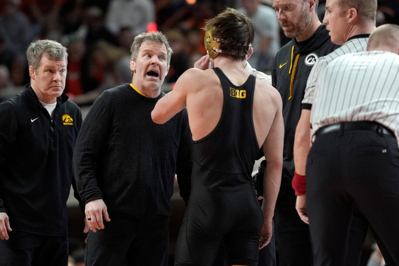 Iowa coach Tom Brands talks with Iowa's Drake Ayala during a college wrestling dual between the Oklahoma State University Cowboys (OSU) and the Iowa Hawkeyes at Gallagher-Iba Arena in Stillwater, Okla., Sunday, Feb. 22, 2026.