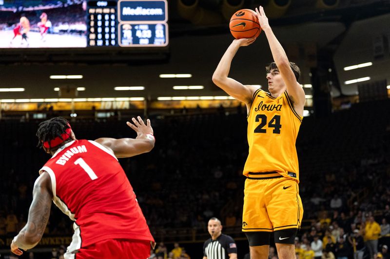 Iowa guard Tate Sage (24) shoots the basketball against Ohio State forward Amare Bynum (1) Feb. 25, 2026 at Carver-Hawkeye Arena in Iowa City, Iowa.
