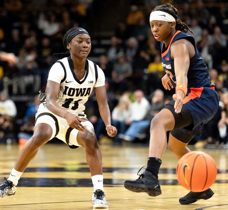Iowa guard Chit-Chat Wright (11) passes the basketball around Illinois guard Destiny Jackson (2) Feb. 26, 2026 at Carver-Hawkeye Arena in Iowa City, Iowa.