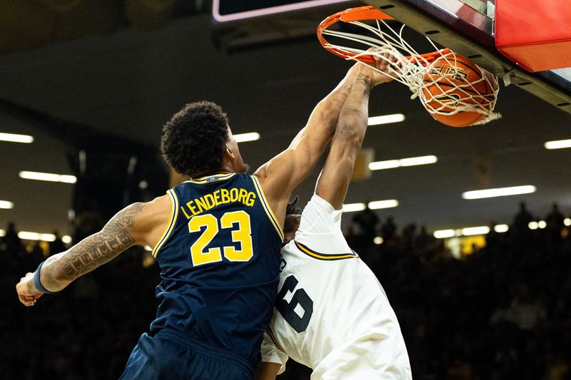 Iowa’s Tavion Banks (6) dunks the basketball as Michigan forward Yaxel Lendeborg (23) defends March 5, 2026 during a Big Ten basketball game at Carver-Hawkeye Arena in Iowa City, Iowa.