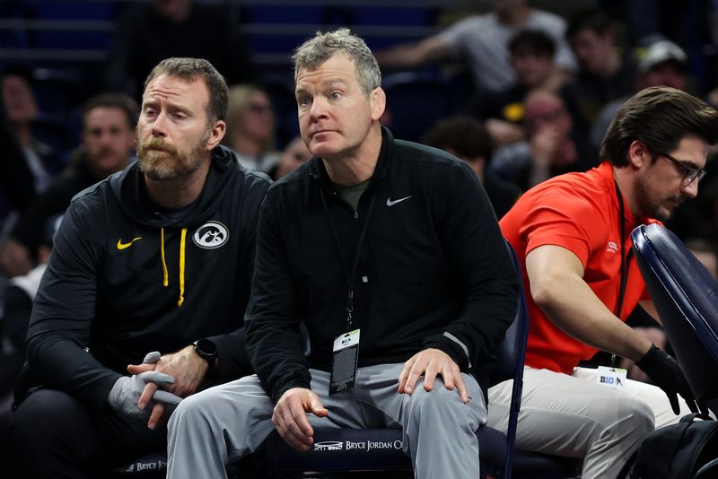 Mar 7, 2026; University Park, PA, USA; Iowa Hawkeyes wrestling head coach Tom Brands (center) looks on as Angelo Ferrari (not pictured) wrestles in a 184-pound bout during the first round of the Big Ten Wrestling Championships at Bryce Jordan Center. Mandatory Credit: Matthew O'Haren-Imagn Images