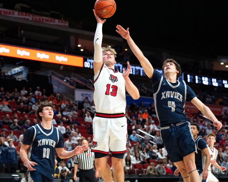 ADM’s Hudson Lorensen (13) shoots the basketball as Xavier's Lorenzo Pino (4) defends March 9, 2026 during the Iowa high school boys state basketball tournament quarterfinals at the Casey’s Center in Des Moines, Iowa.