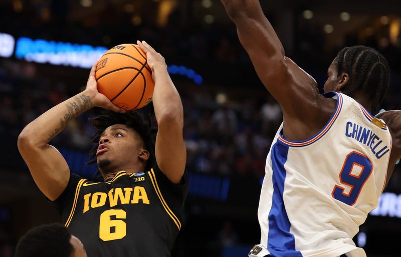 Mar 22, 2026; Tampa, FL, USA; Iowa Hawkeyes guard Tavion Banks (6) goes to the basket against Florida Gators center Rueben Chinyelu (9) in the first half during a second round game of the men's 2026 NCAA Tournament at Benchmark International Arena. Mandatory Credit: Matt Pendleton-Imagn Images