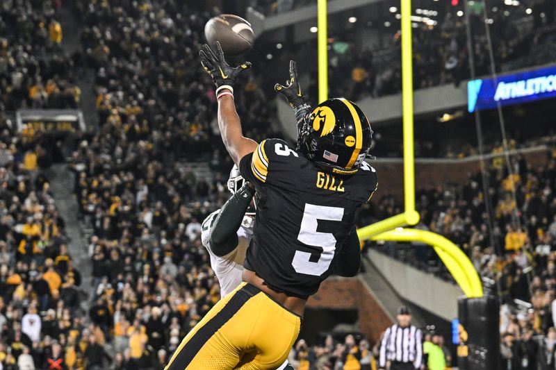 Nov 22, 2025; Iowa City, Iowa, USA; Iowa Hawkeyes wide receiver Jacob Gill (5) catches the game tying touchdown as Michigan State Spartans defensive back Dontavius Nash (28) defends during the fourth quarter at Kinnick Stadium. Mandatory Credit: Jeffrey Becker-Imagn Images