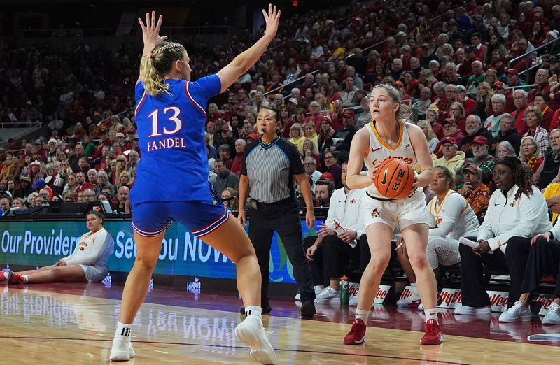 Iowa State Cyclones' guard Kenzie Hare (12) looks for a three-point shot around Kansas Jayhawks guard Libby Fandel (13) during the fourth-quarter in the Big-12 conference home opener on Dec. 21, 2025, at Hilton Coliseum in Ames, Iowa.