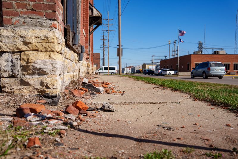 Bricks that have fallen from the old Carter hotel sit on the sidewalk next to the building in Montezuma, March 27, 2026.