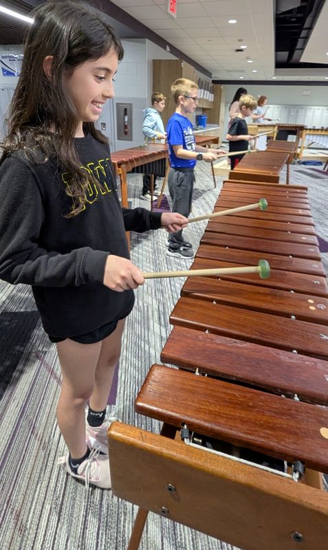 Fourth grader Corra Varzavand enjoys playing with one of two elementary marimba bands at East Ridge Elementary in Coralville. Next to her are Jameson Parrish, Dawson Haas, and Byron Clark in the background.