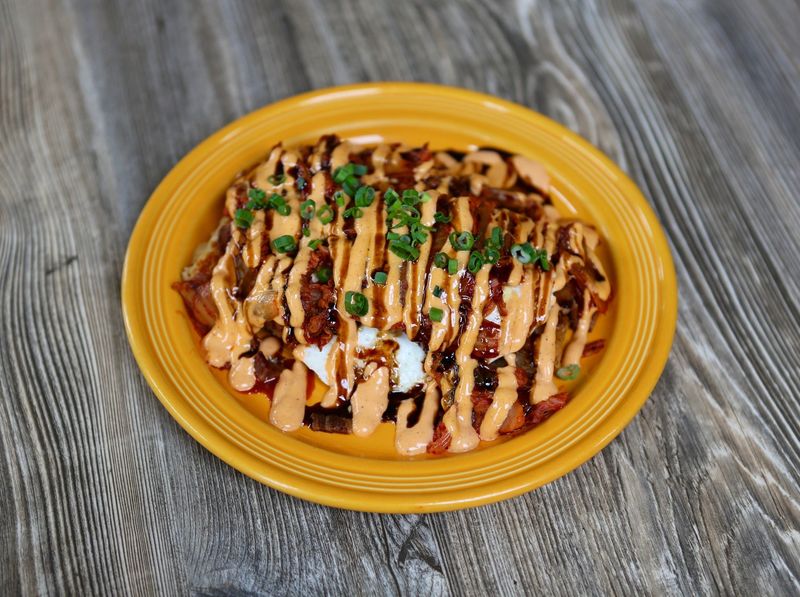 Seoul Food features hash browns topped with bacon, kimchi, green onion, sriracha mayo, soy reduction and over easy eggs at The Breakfast Club, with three locations in the Des Moines metro.