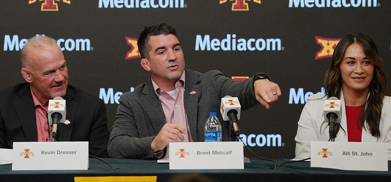 Iowa State new men’s wrestling head coach Brent Metcalf speaks as new wrestling director Kevin Dresser and new women wrestling head coach Alli St.John look on 
 during a press conference at Hilton Coliseum on April. 16, 2026, in Ames, Iowa