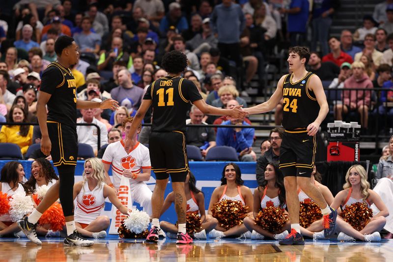 Mar 20, 2026; Tampa, FL, USA; Iowa Hawkeyes guard Tate Sage (24), right, celebrates with guard Kael Combs (11), center, in the first half against the Clemson Tigers during a first round game of the men's 2026 NCAA Tournament at Benchmark International Arena. Mandatory Credit: Matt Pendleton-Imagn Images