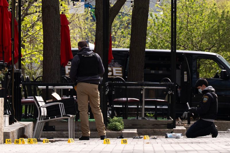 Iowa City law enforcement personnel investigate at the scene of a shooting April 19, 2026 on the pedestrian mall in downtown Iowa City, Iowa.