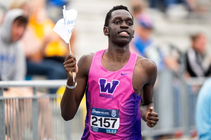 Waukee’s Ajak Malual carries Drake Relays flag after winning the boys high jump on April 23, 2026, at Drake Stadium in Des Moines.