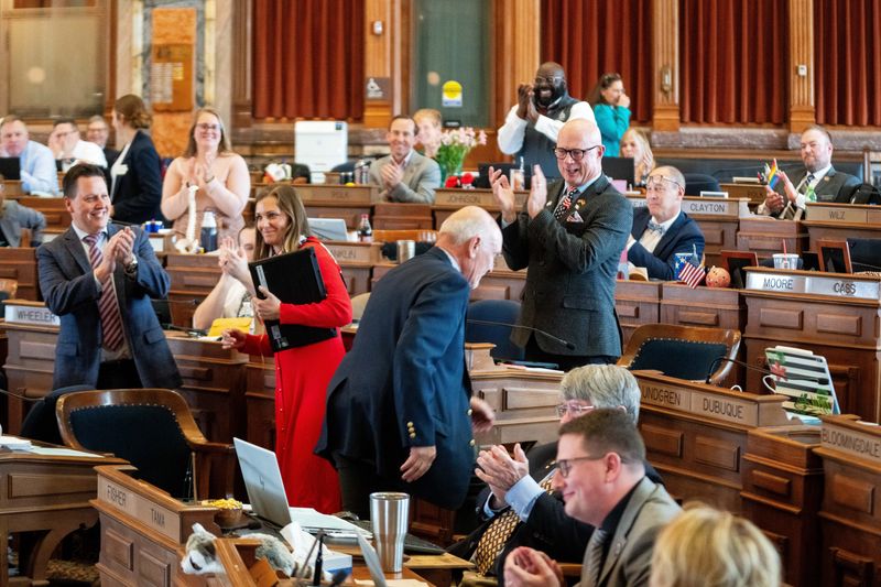 Members of the Iowa House stand in applause as Rep. Rick Olson returns to his desk on April 28, 2026, at the Iowa State Capitol.