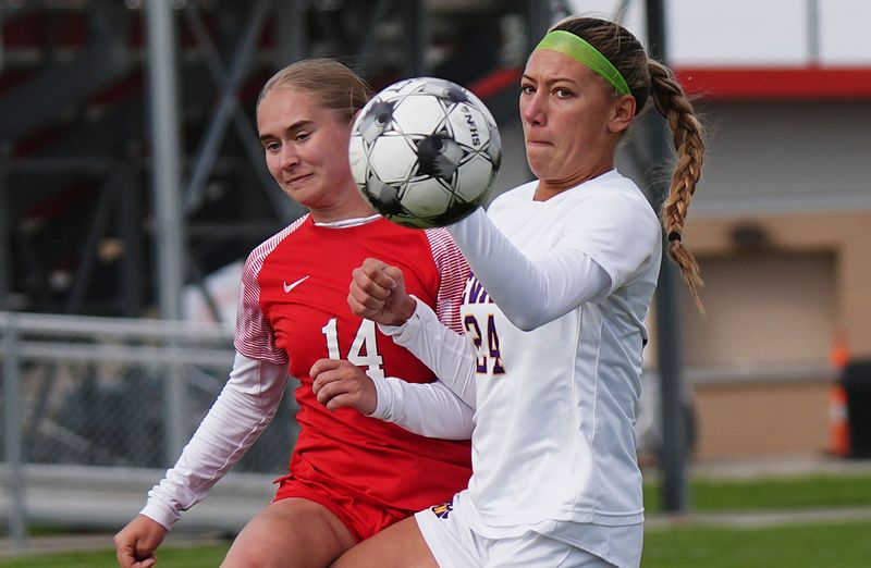 Nevada midfielder Rachel Borwick (24) and Gilbert midfielder Greta Platts (14) battle for the ball during the first half of Gilbert's 5-0 victory in high school girls soccer at the Gilbert grass soccer field on April 30 in Gilbert, Iowa.