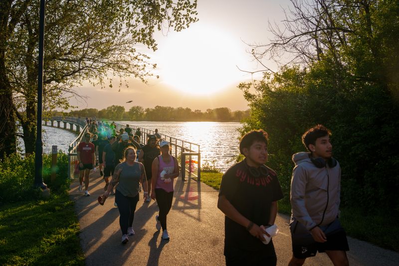 More than 100 participants join the 515 Run Club to pick up trash as they walk around Gray's Lake, May 4, 2026, in Des Moines.