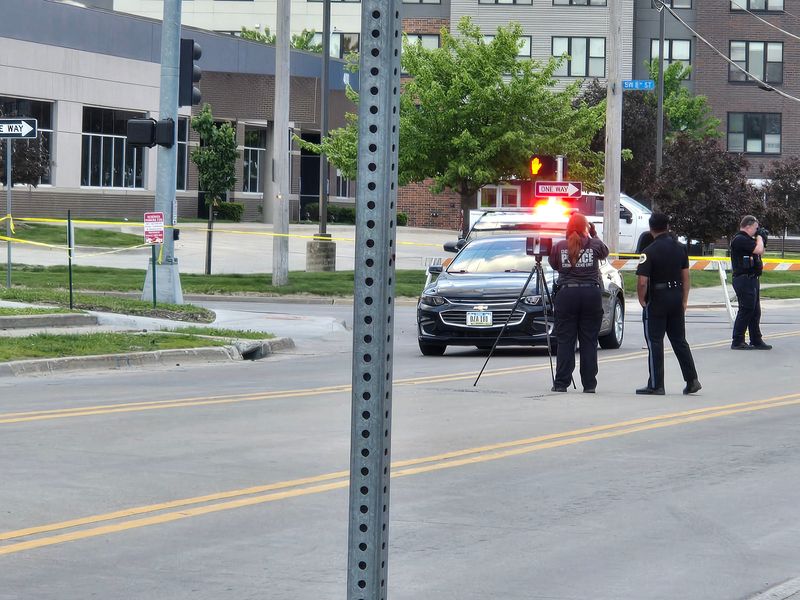 Des Moines police crime scene technicians investigate at the scene of a downtown Des Moines shooting that left a man dead and a woman in critical condition on Friday, May 8.