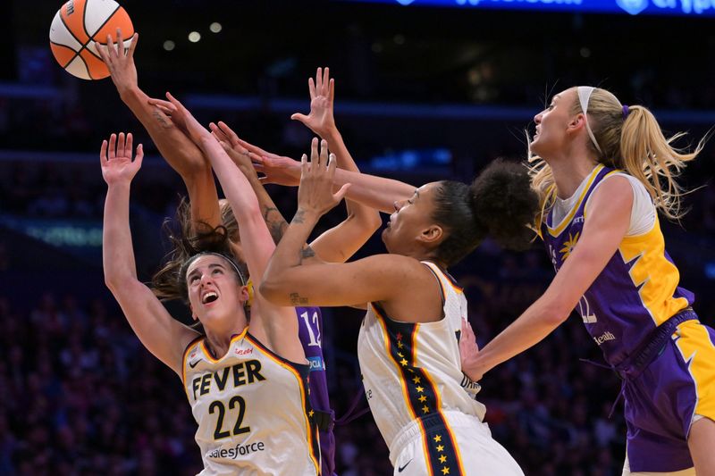 May 13, 2026; Los Angeles, California, USA; Indiana Fever guard Caitlin Clark (22), center Damiris Dantas (12), Los Angeles Sparks guard Rae Burrell (12) and forward Cameron Brink (22) battle for a rebound in the first half at Crypto.com Arena. Mandatory Credit: Jayne Kamin-Oncea-Imagn Images
