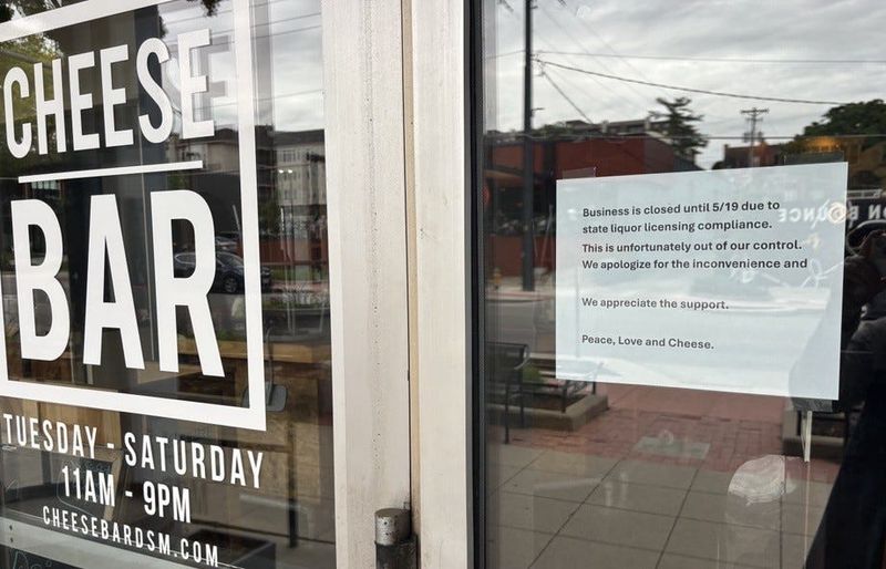 A sign posted in the Cheese Bar's window May 14, 2026. The restaurant temporarily closed for a week after it was unable to get its alcohol license renewed by the deadline.