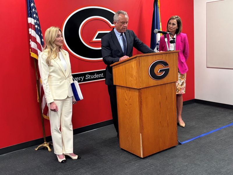 Health and Human Services Secretary Robert F. Kennedy Jr. (center) announced the release of the U.S. Surgeon General's advisory on the harms of device usage and screen time by youth at Gilbert Elementary School May 20. Dr. Stephanie Haridopolos, director of National Health Communications for the Surgeon General's office, (left) and Gov. Kim Reynolds joined Kennedy for the announcement.