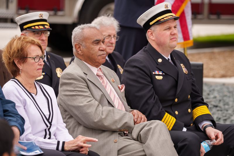 Former Des Moines firefighter Milford Fonza sits between Mayor Connie Boesen and Fire Chief Jonathan Lund during an opening ceremony for Fire Station 4 on, May 22, 2026. In 1967 Fonza became the first Black firefighter in Des Moines since 1919.