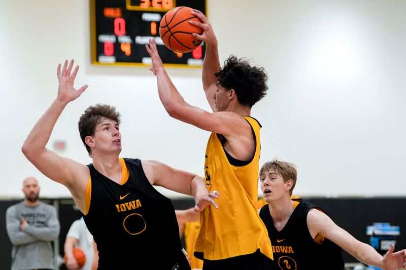 Iowaâ€™s Isaia Howard (23) looks to pass as Trevin Jirak (27) and Cooper Koch (8) defend during practice June 19, 2025 at Carver-Hawkeye Arena in Iowa City, Iowa.