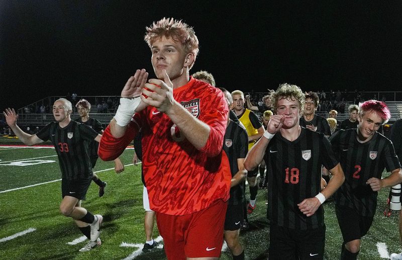 Gilbert keeper Tyler Jerkins (front) and Mitch Walter (18) celebrate with their teammates celebrates defeating Aplington-Parkersburg/Dike-New Hartford United in a sudden-death shootout, 1-0 (6-5) in the Class 2A boys state soccer quarterfinal game at Tiger Stadium on June 1 in Gilbert, Iowa. Jerkins made two clutch saves in the second shootout and Walter scored the winning goal in the shootout.