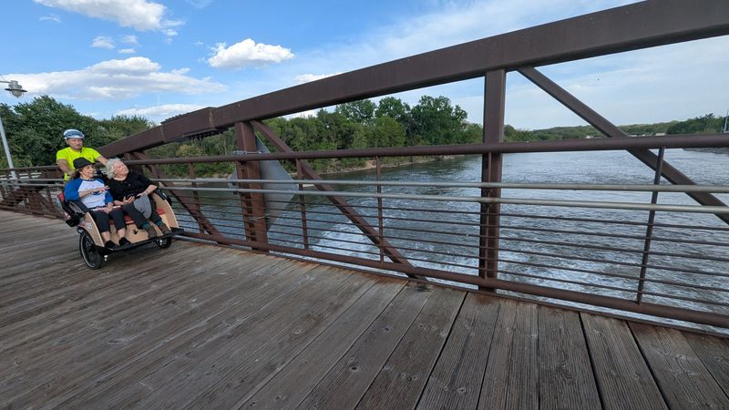 Scenic views abound on the Iowa River Trail, including this one where Cycling Without Age passengers can enjoy the rolling river while crossing on this pedestrian bridge.