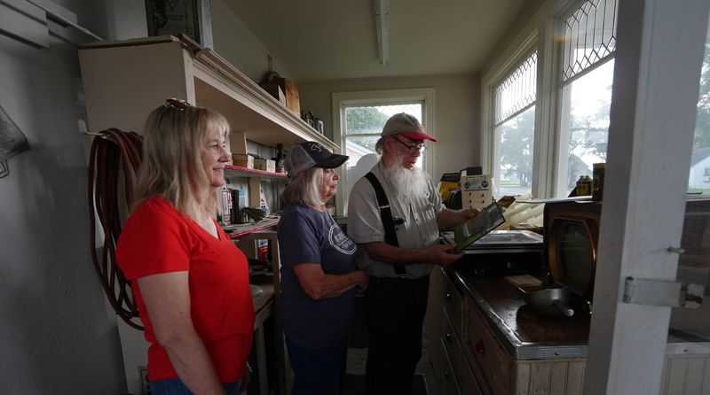 Reed-Niland Corner restoration committee members Paula Cady and Susan McKinney join Mike Kelly, former manager of Niland's Cafe and the Colo Motel, at Reed’s Gas Station Museum in Colo, Iowa.