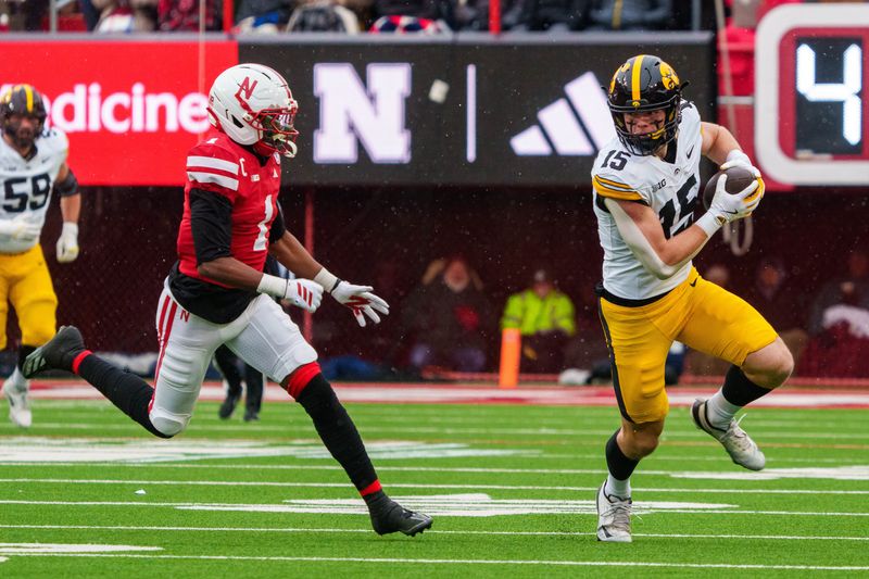 Nov 28, 2025; Lincoln, Nebraska, USA; Iowa Hawkeyes wide receiver Reece Vander Zee (15) runs against Nebraska Cornhuskers defensive back Ceyair Wright (1) during the third quarter at Memorial Stadium. Mandatory Credit: Dylan Widger-Imagn Images