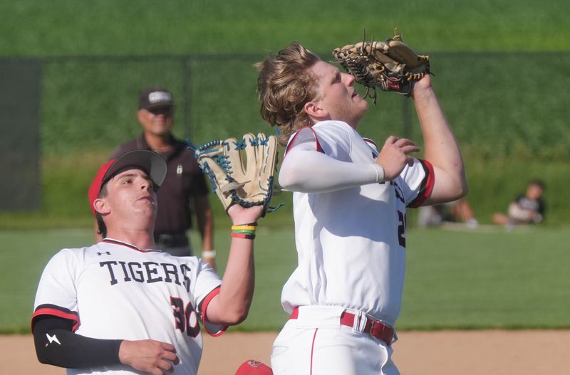 Gilbert third baseman Matt Zoz (20) catches a ball as pitcher Tripp Sturgill (30) looks on during a doubleheader against Adel-Desoto-Minburn at the Gilbert baseball field on June 22 in Gilbert, Iowa.