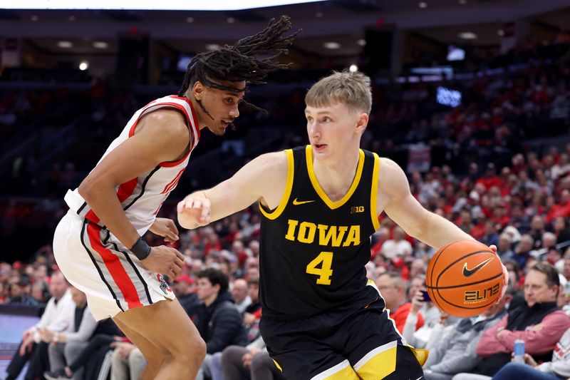 Jan 27, 2025; Columbus, Ohio, USA;  Iowa Hawkeyes guard Josh Dix (4) dribbles the ball as Ohio State Buckeyes forward Devin Royal (21) defends during the first half at Value City Arena. Mandatory Credit: Joseph Maiorana-Imagn Images