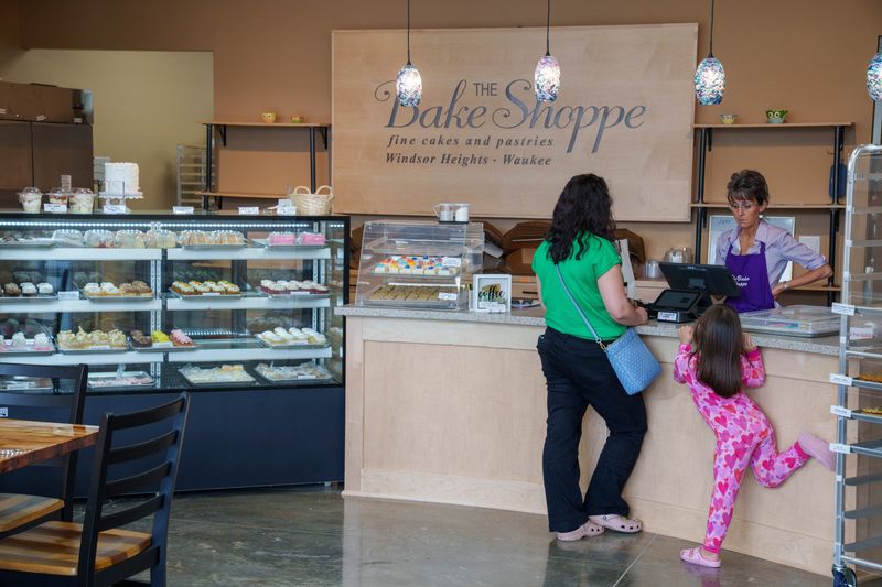 Kristi Jones and her daughter Harper, 4, place an order for cupcakes for Harper’s birthday with The Bake Shoppe’s manager Sheryl Woolman at its new location in Waukee, Iowa, Friday, June 26, 2026.