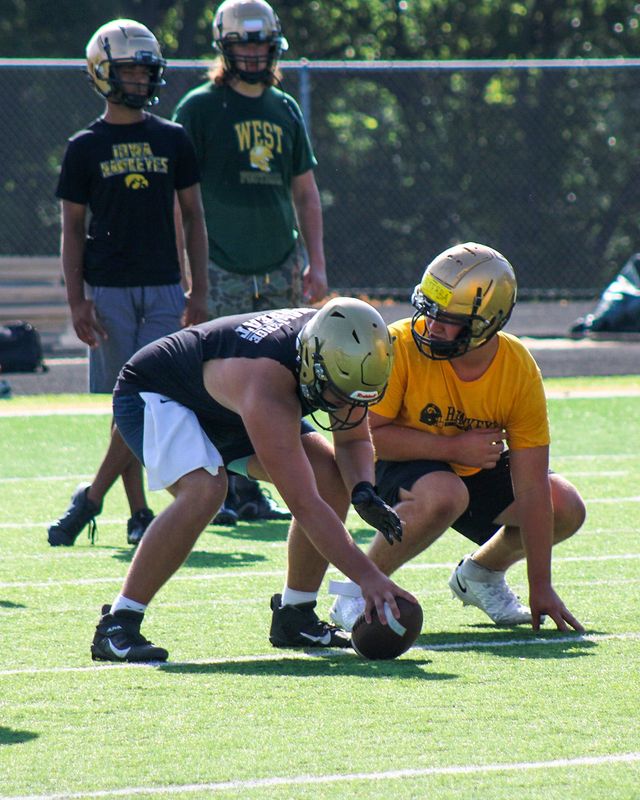 Rising junior James Barnett, left,  gets ready to snap the ball during a West High practice on June 29. Barnett, the son of Iowa offensive line coach George Barnett, was offered by the Hawkeyes in June.
