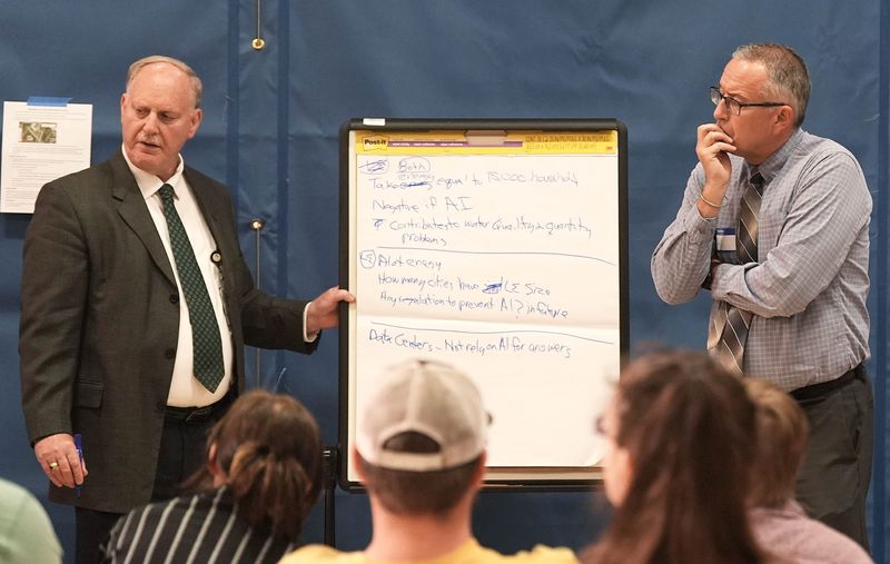 City manager Steve Schainker and city council member Tim Gartin speak during the Ames City Council's listening session about a possible data center on Tuesday, June 30, at City Auditorium in Ames, Iowa.