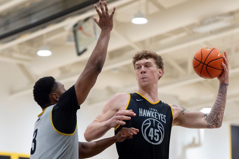 Iowa center Andrew McKeever passes the ball around Cam Manyawu during a summer basketball practice July 8, 2026 at Carver-Hawkeye Arena in Iowa City, Iowa.
