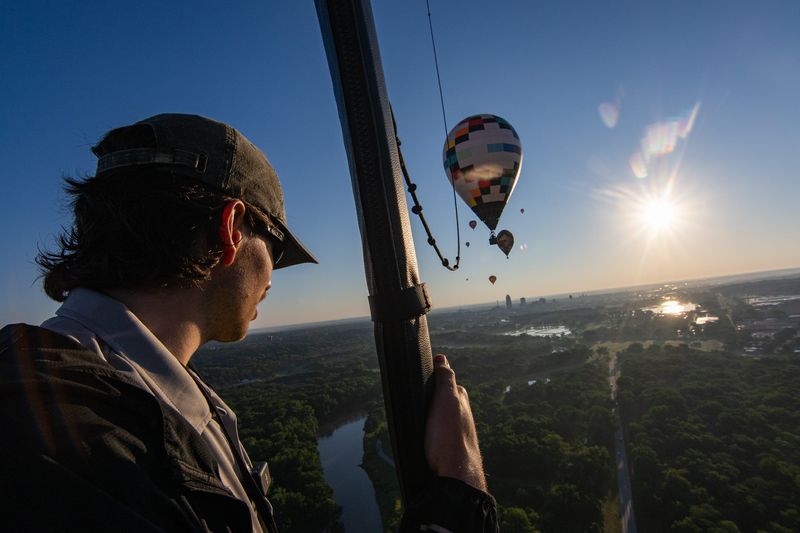 Des Moines Register reporter Cooper Worth looks toward the Des Moines, Iowa, skyline from a hot air balloon on July 13, 2026.