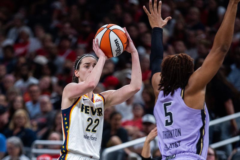 Jul 15, 2026; Indianapolis, Indiana, USA; Indiana Fever guard Caitlin Clark (22) shoots the ball while Golden State Valkyries forward Kayla Thornton (5) defends in the first half at Gainbridge Fieldhouse. Mandatory Credit: Trevor Ruszkowski-Imagn Images