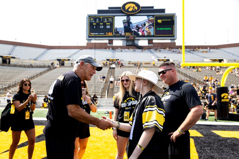 Aug 9, 2025; Iowa head coach Kirk Ferentz greets families of Kid Captains during the Hawkeyes Kids Day NCAA football open practice at Kinnick Stadium in Iowa City, Iowa. Mandatory Credit: Joseph Cress for the Des Moines Register