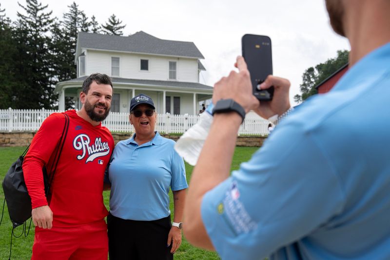 Philadelphia Phillies designated hitter Kyle Schwarber takes a photo with a fan Aug. 13, 2026 at the Field of Dreams in Dyersville, Iowa.