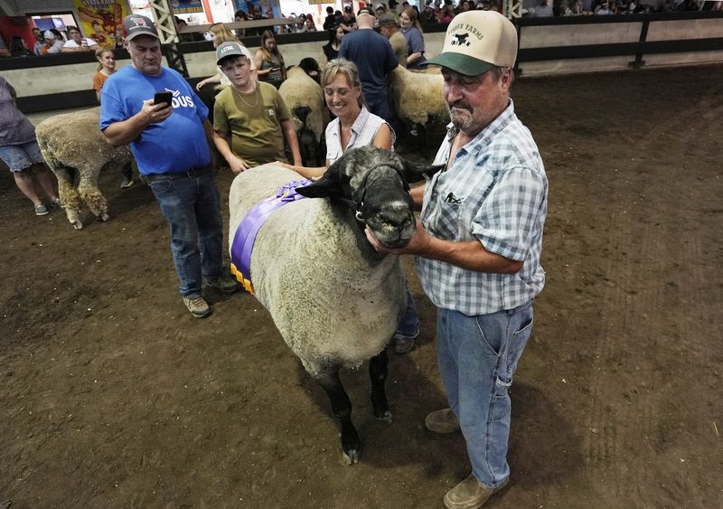 Jim Fisher holds his sheep after winning Big Ram contest on the first day of the Iowa State Fair on Aug. 13, 2026. Big Bad Joe broke an Iowa State Fair record and may set a Guinness World Record.