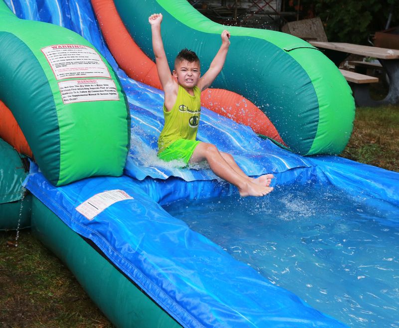 Cullen Lazaro takes a trip down the waterslide at the Whittenton Block Party at the Broken Chains Biker Church on Thursday, Aug. 11, 2022.