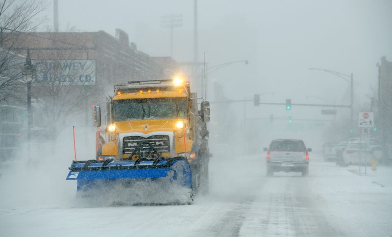 A snow plow clears off the southbound lane of SW Adams Street as snow falls throughout the Peoria area Thursday, Dec. 22, 2022 in Peoria.