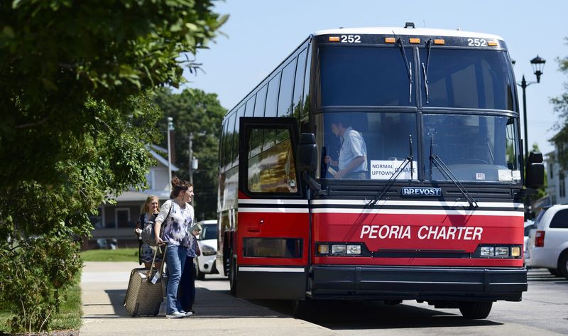 In this file photo, passengers board a Peoria Charter Coach bus at Bradley University.